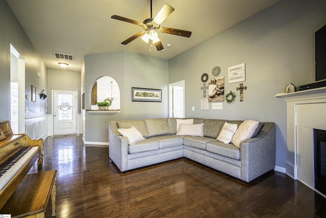 unfurnished living room with wood finished floors, baseboards, visible vents, a ceiling fan, and a glass covered fireplace