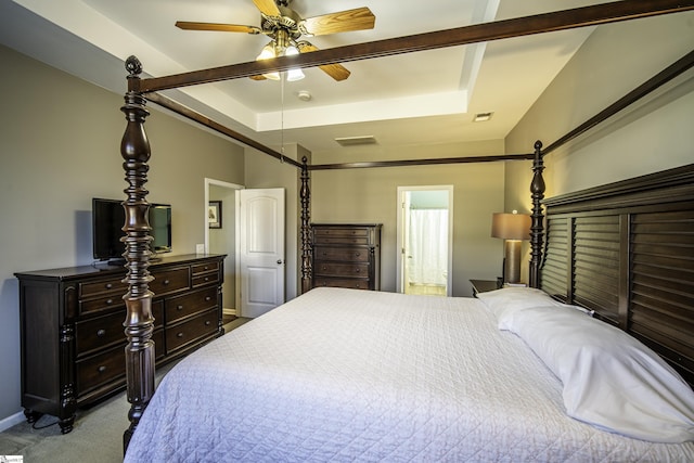 carpeted bedroom featuring visible vents, a raised ceiling, and baseboards