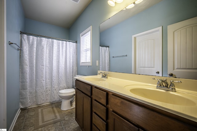 bathroom featuring a sink, toilet, and double vanity