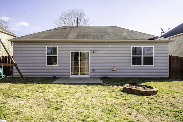 back of house featuring a lawn, an outdoor fire pit, a patio, and fence