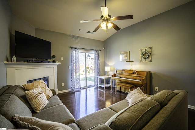 living area featuring visible vents, wood finished floors, baseboards, ceiling fan, and vaulted ceiling