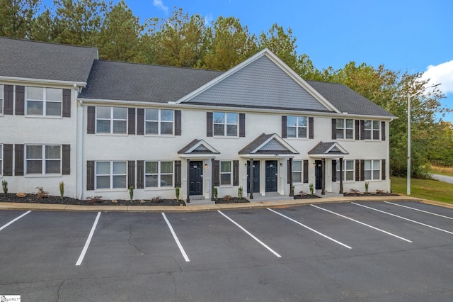 multi unit property featuring brick siding and uncovered parking