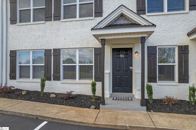 view of exterior entry featuring brick siding