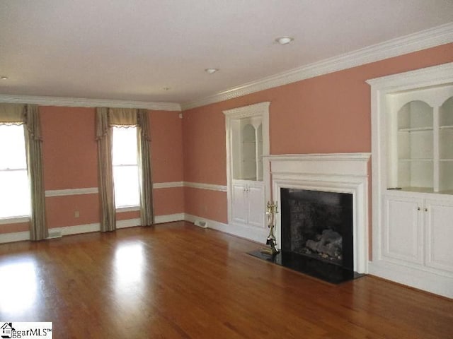 unfurnished living room with a fireplace with flush hearth, ornamental molding, and wood finished floors