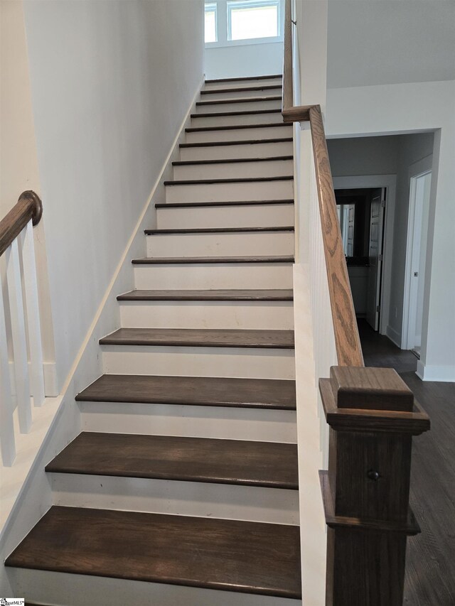 stairway featuring baseboards and wood finished floors