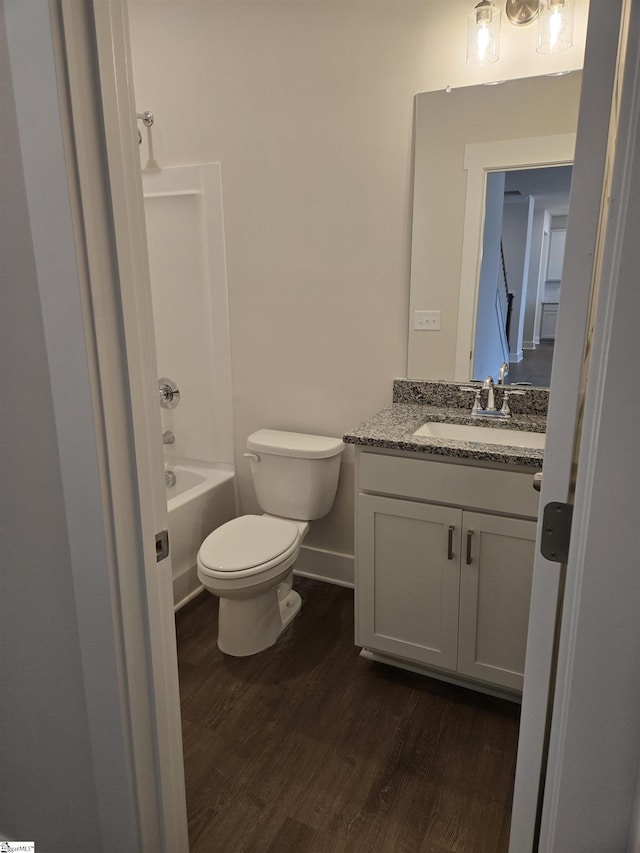 full bath with baseboards, toilet, shower / bathtub combination, wood finished floors, and vanity