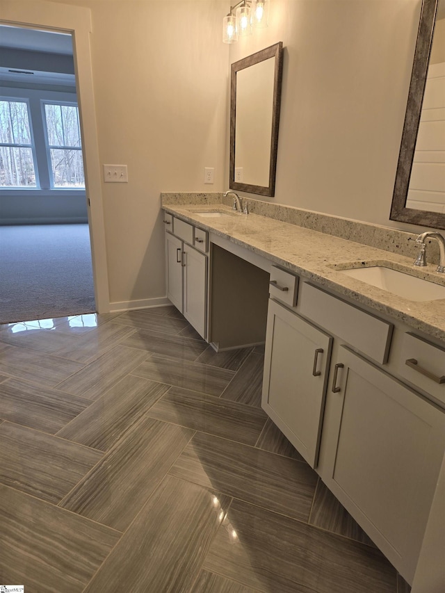 full bathroom featuring double vanity, baseboards, and a sink