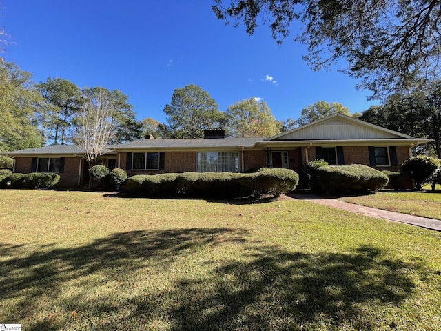 ranch-style house featuring brick siding and a front yard