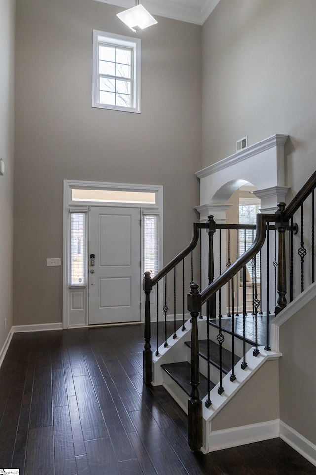 foyer entrance featuring hardwood / wood-style floors, plenty of natural light, and a towering ceiling