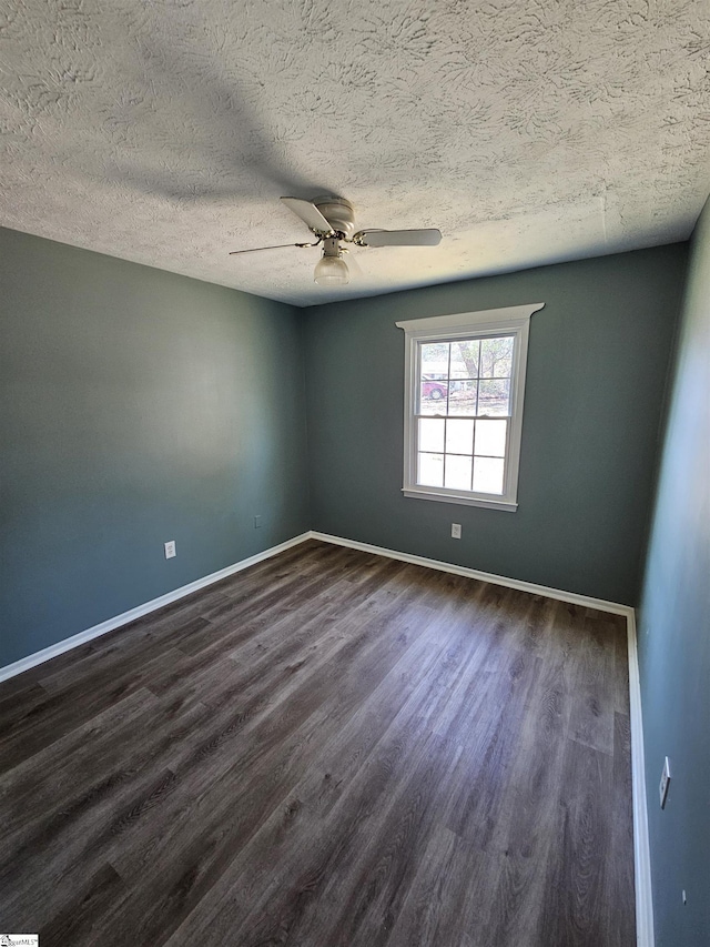 spare room featuring baseboards, a textured ceiling, dark wood-style floors, and a ceiling fan