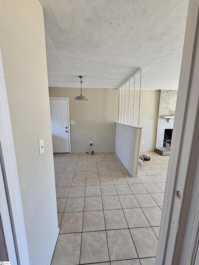 interior space featuring light tile patterned floors, a textured ceiling, and a fireplace