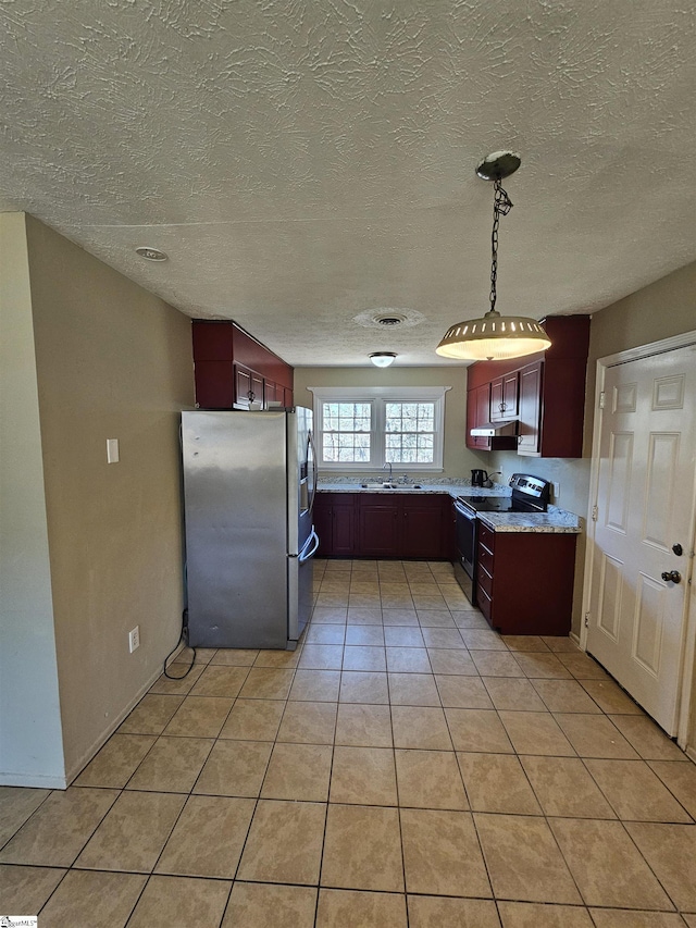 kitchen with pendant lighting, light tile patterned floors, appliances with stainless steel finishes, a textured ceiling, and a sink