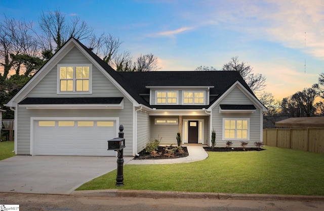 view of front of home with fence, roof with shingles, a front yard, a garage, and driveway