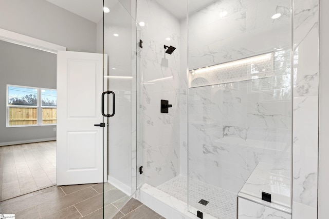 bathroom featuring a marble finish shower