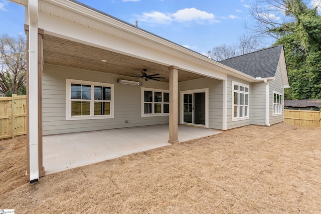 back of property with a shingled roof, fence, ceiling fan, and a patio area