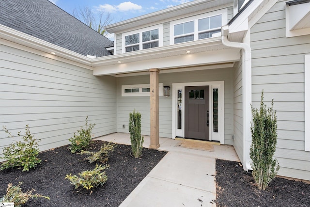 doorway to property with a shingled roof