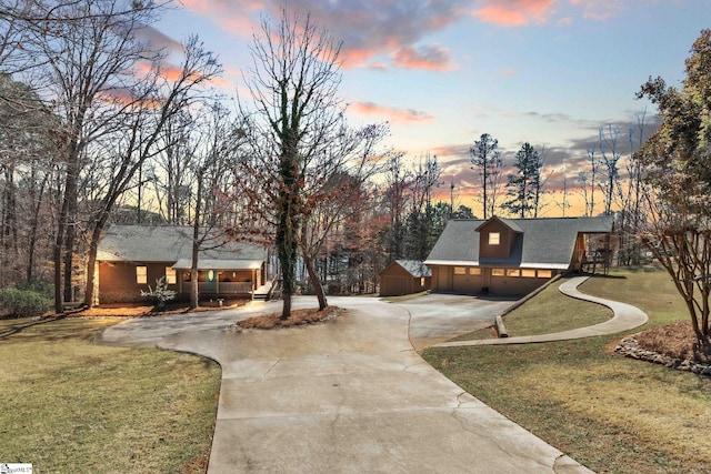 view of home's community with a lawn, a garage, and driveway