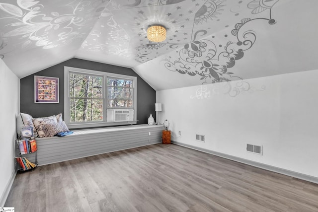 additional living space with lofted ceiling, wood finished floors, visible vents, and baseboards