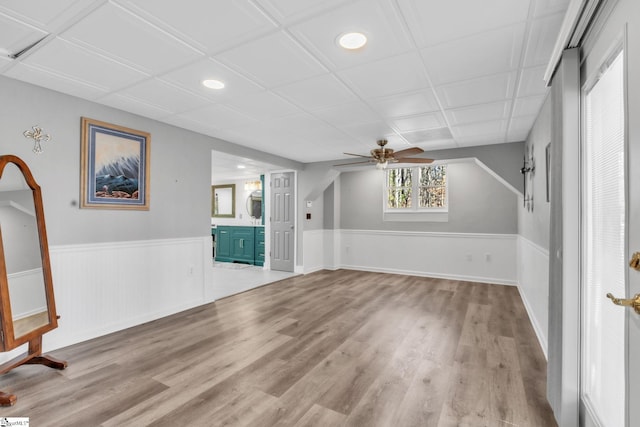 interior space with wainscoting, a ceiling fan, and wood finished floors