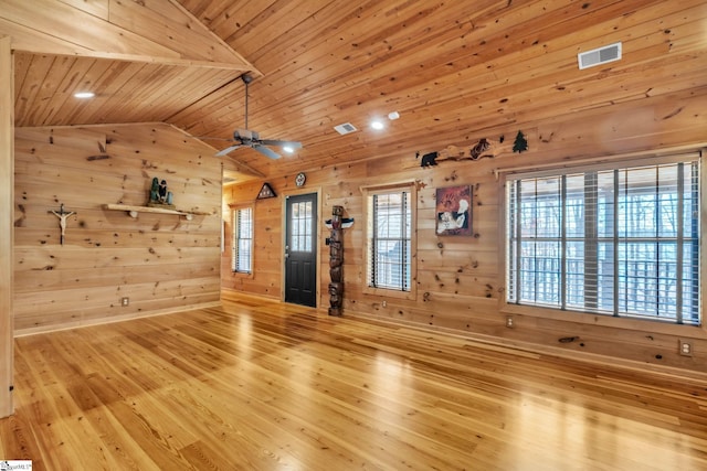 unfurnished living room featuring visible vents, wood finished floors, wooden walls, wood ceiling, and vaulted ceiling