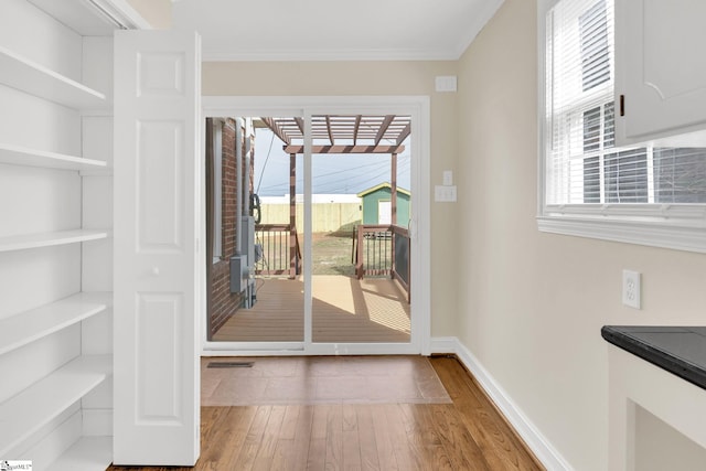 entryway with plenty of natural light, ornamental molding, baseboards, and wood finished floors