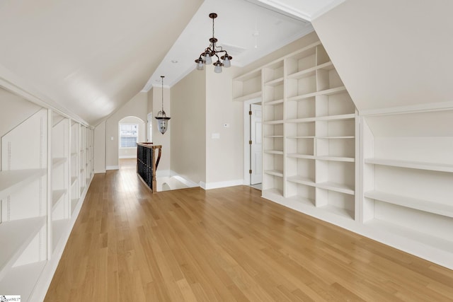 bonus room with built in shelves, baseboards, lofted ceiling, light wood-style floors, and a notable chandelier