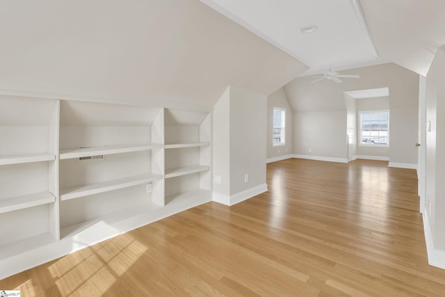 bonus room featuring built in features, a ceiling fan, baseboards, lofted ceiling, and light wood-style flooring