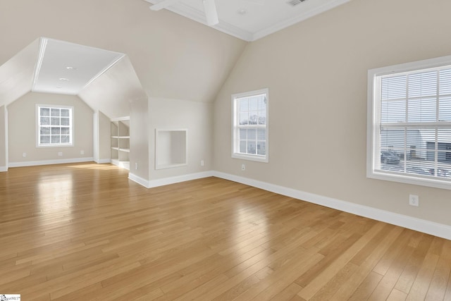 additional living space featuring light wood finished floors, visible vents, baseboards, vaulted ceiling, and a ceiling fan