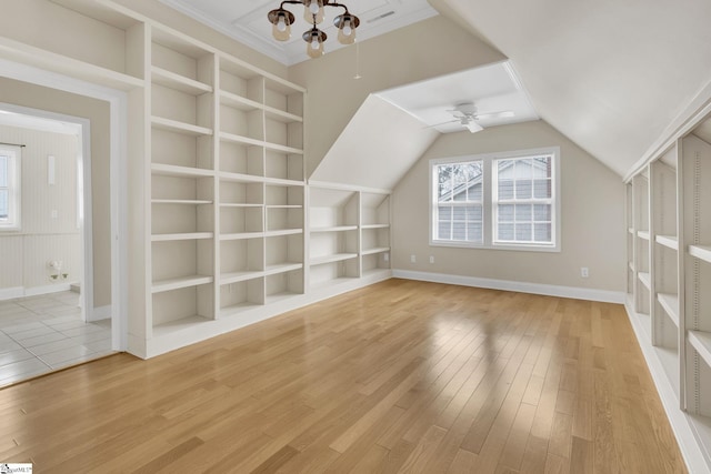 bonus room with built in shelves, baseboards, ceiling fan, vaulted ceiling, and light wood-type flooring