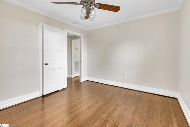 unfurnished room featuring hardwood / wood-style floors, visible vents, baseboards, and ornamental molding