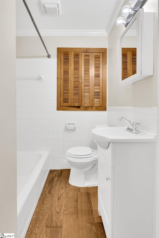 full bath featuring visible vents, toilet, wood finished floors, tile walls, and vanity