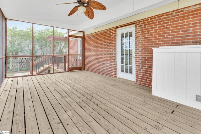 unfurnished sunroom with ceiling fan