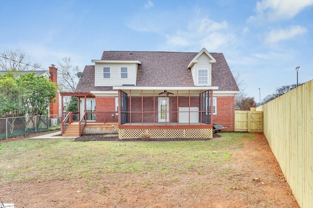 back of house featuring a wooden deck, brick siding, a fenced backyard, and a lawn