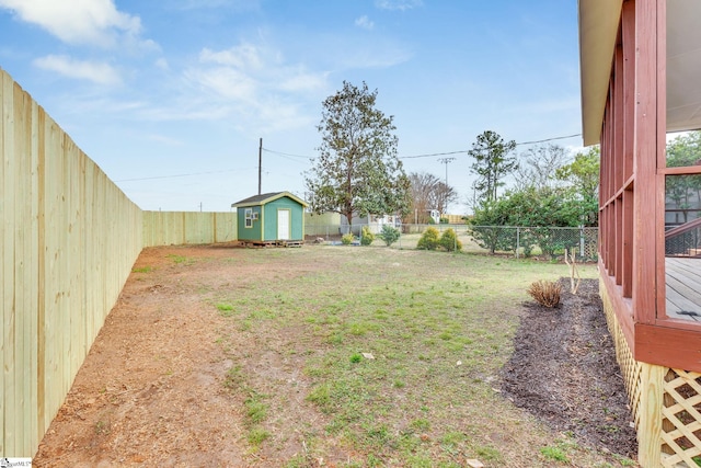 view of yard featuring a storage shed, an outbuilding, and a fenced backyard