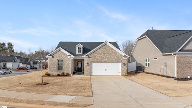 view of front of home with brick siding, central AC, and driveway