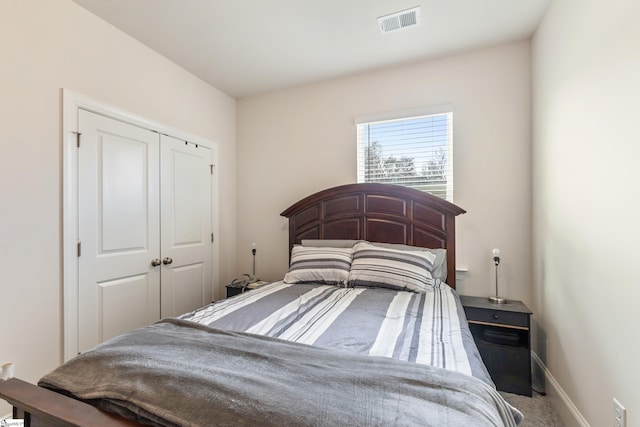 bedroom featuring a closet, visible vents, carpet flooring, and baseboards