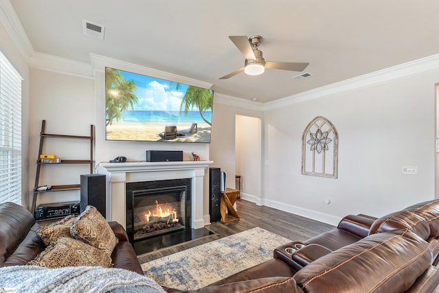 living room with visible vents, a fireplace with flush hearth, and ornamental molding