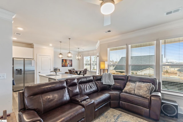 living room featuring visible vents and ornamental molding