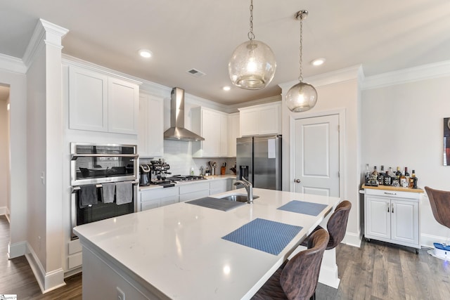 kitchen with dark wood-style flooring, stainless steel appliances, light countertops, wall chimney range hood, and tasteful backsplash