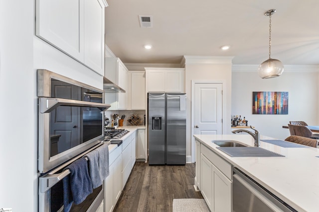 kitchen with visible vents, decorative backsplash, white cabinets, stainless steel appliances, and a sink