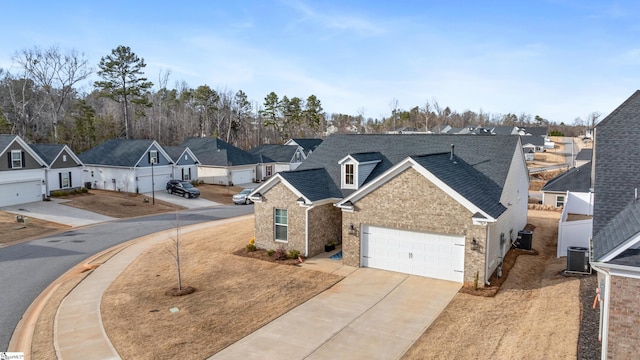 traditional home featuring a residential view, central AC, roof with shingles, a garage, and driveway