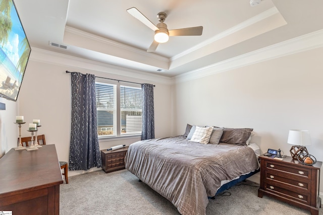 bedroom with a raised ceiling, crown molding, and light colored carpet