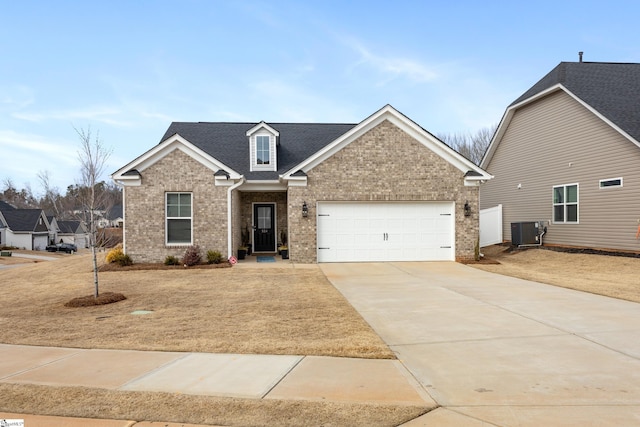 view of front facade with brick siding, concrete driveway, central AC, roof with shingles, and a garage