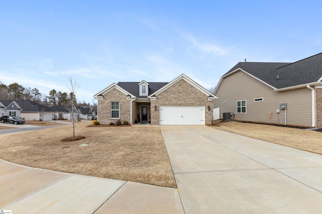 view of front facade featuring a garage, central air condition unit, brick siding, and driveway