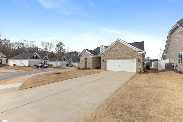 view of front of house with cooling unit, fence, driveway, brick siding, and a residential view