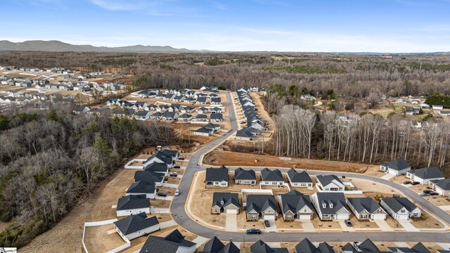 birds eye view of property featuring a mountain view, a residential view, and a view of trees