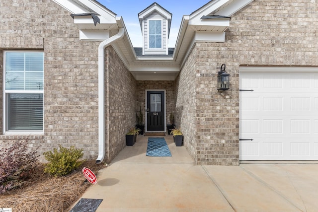 entrance to property with brick siding and an attached garage