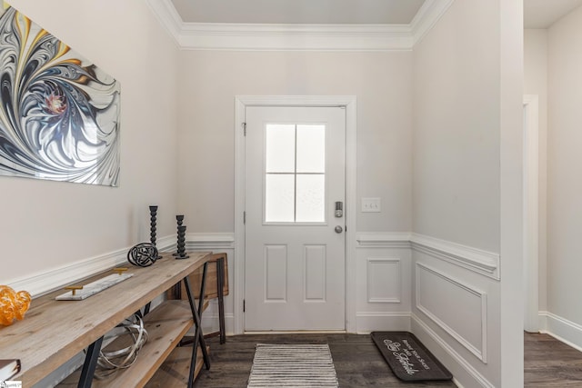 doorway to outside with dark wood-type flooring, a decorative wall, crown molding, and a wainscoted wall