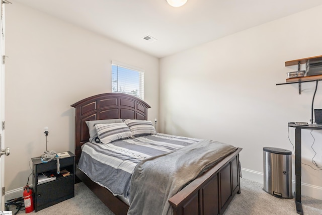 bedroom with baseboards, visible vents, and light carpet