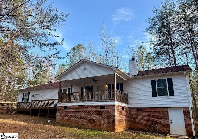 view of front of property with a wooden deck, a chimney, and ceiling fan